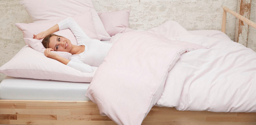 Frau im Bett Bettwäsche hell rosa