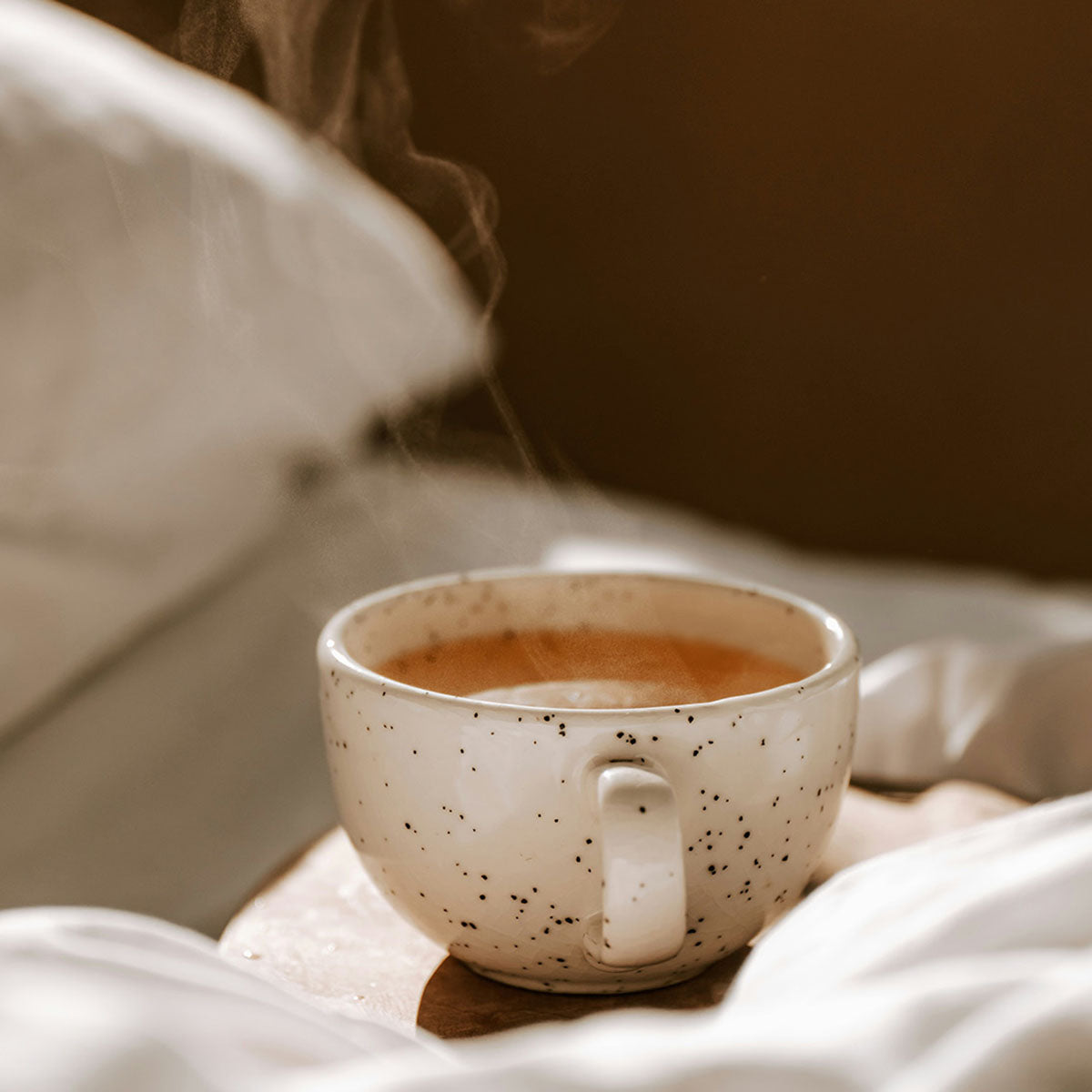 Tasse Tee dampfend im Bett
