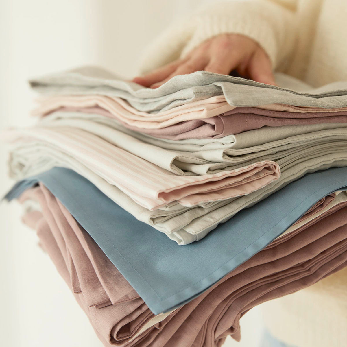 Halbleinen Bettwäsche Mix Stapel zwischen Händen