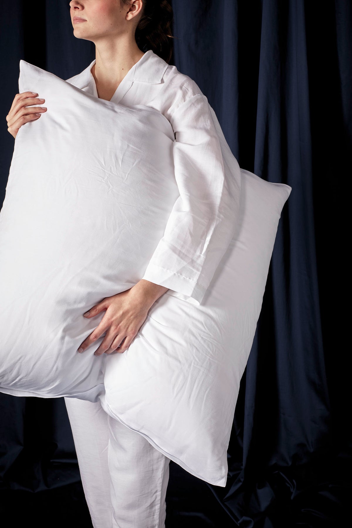 Frau stehend mit Kissen unter dem Arm